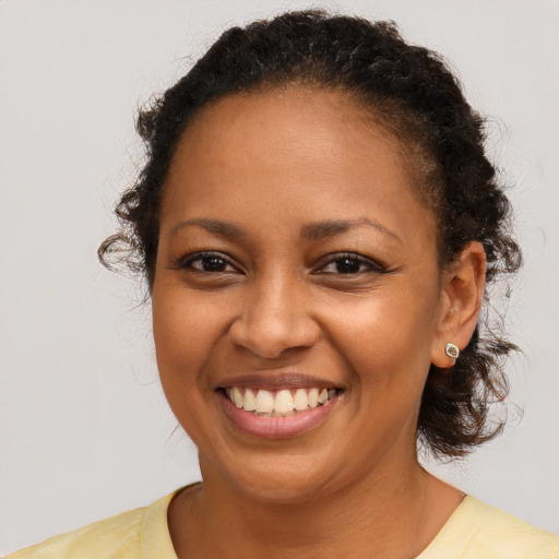 Joyful black young-adult female with medium  brown hair and brown eyes