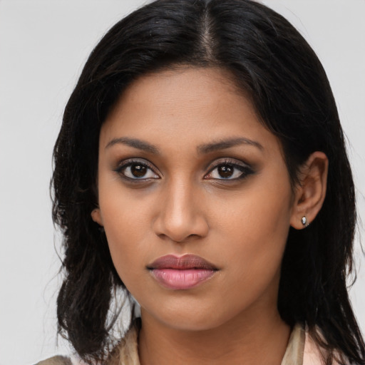 Joyful latino young-adult female with long  brown hair and brown eyes