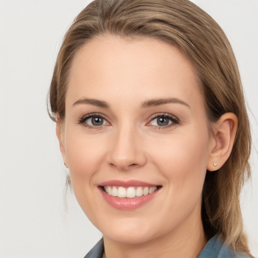 Joyful white young-adult female with medium  brown hair and grey eyes