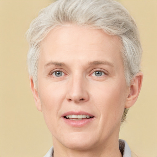 Joyful white adult female with short  blond hair and grey eyes