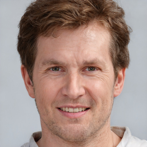 Joyful white adult male with short  brown hair and grey eyes