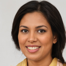 Joyful latino young-adult female with medium  brown hair and brown eyes