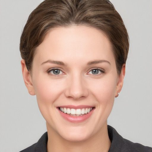 Joyful white young-adult female with short  brown hair and grey eyes