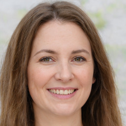 Joyful white adult female with long  brown hair and green eyes