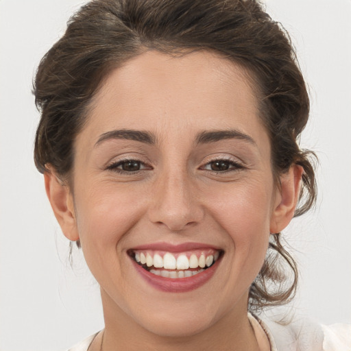 Joyful white young-adult female with medium  brown hair and grey eyes