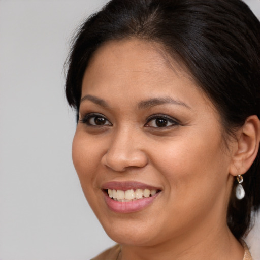 Joyful latino young-adult female with medium  brown hair and brown eyes