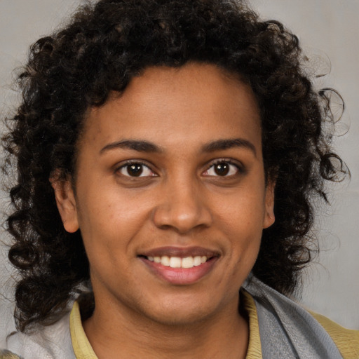 Joyful black young-adult female with medium  brown hair and brown eyes