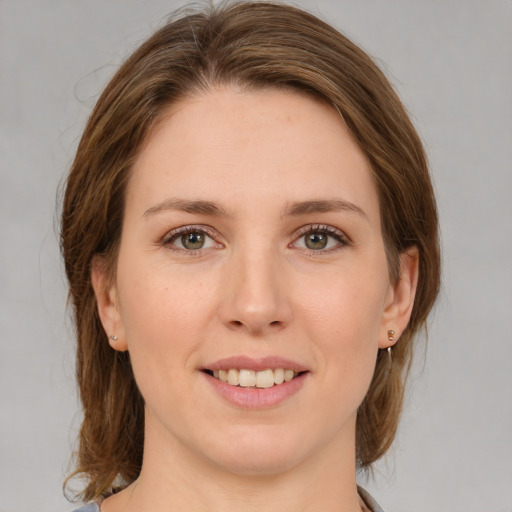 Joyful white young-adult female with medium  brown hair and green eyes