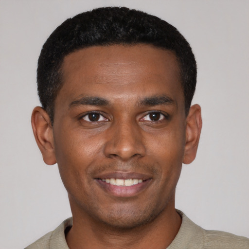 Joyful black young-adult male with short  black hair and brown eyes