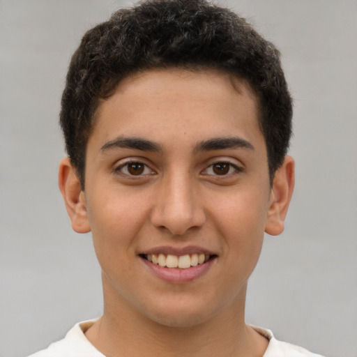 Joyful latino young-adult male with short  brown hair and brown eyes