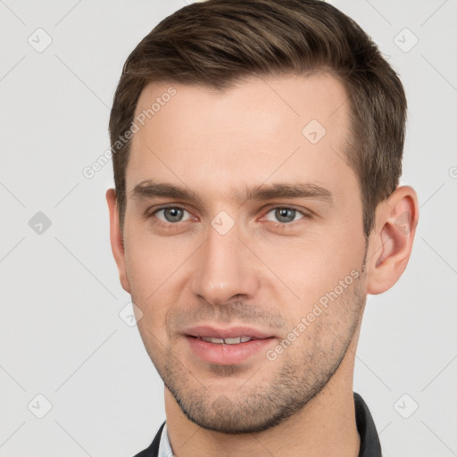 Joyful white young-adult male with short  brown hair and grey eyes