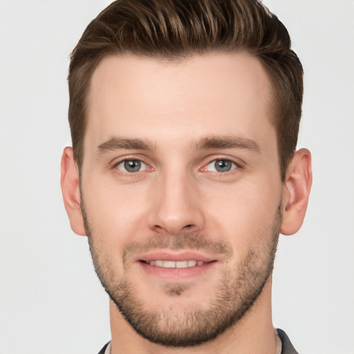 Joyful white young-adult male with short  brown hair and grey eyes