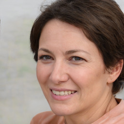 Joyful white adult female with medium  brown hair and brown eyes