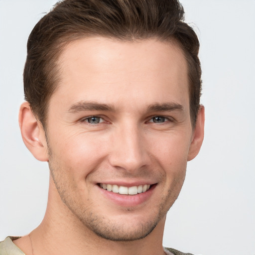 Joyful white young-adult male with short  brown hair and grey eyes