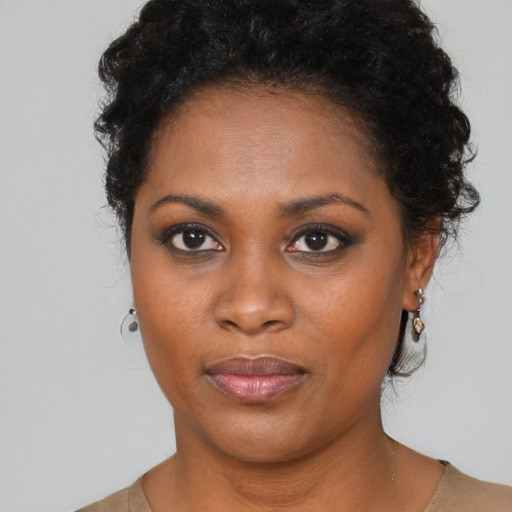 Joyful black young-adult female with medium  black hair and brown eyes
