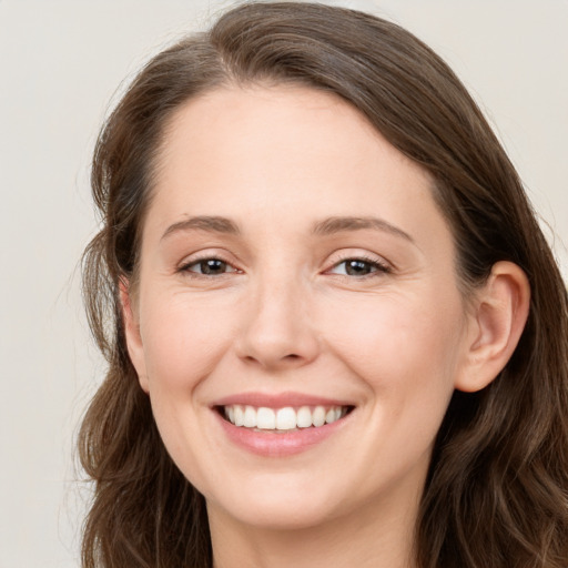 Joyful white young-adult female with long  brown hair and grey eyes