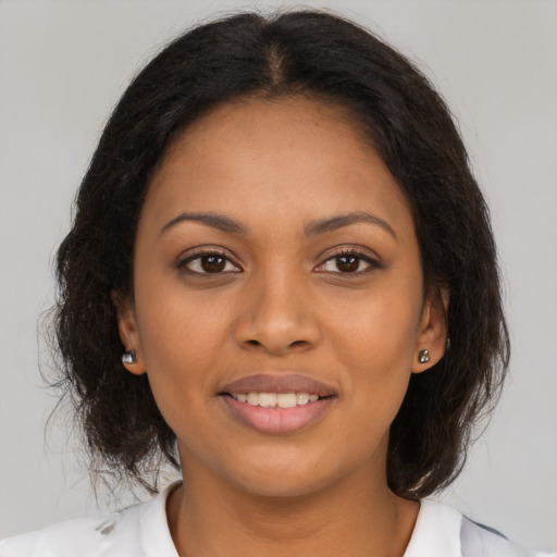 Joyful black young-adult female with medium  brown hair and brown eyes