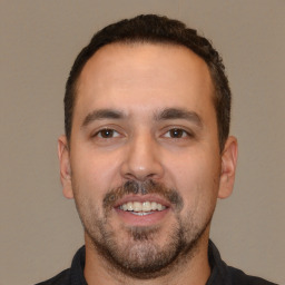 Joyful white young-adult male with short  black hair and brown eyes