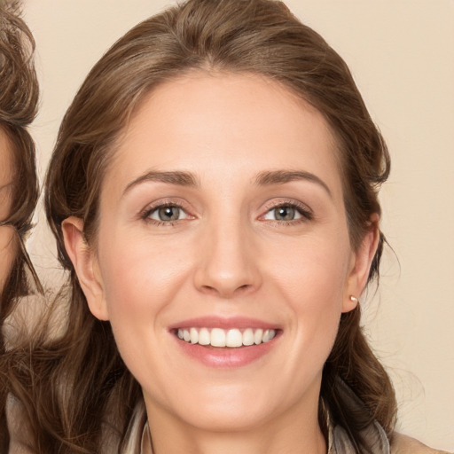 Joyful white young-adult female with long  brown hair and green eyes