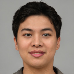 Joyful asian young-adult male with short  brown hair and brown eyes