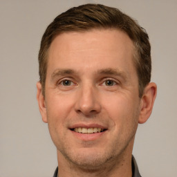 Joyful white adult male with short  brown hair and brown eyes