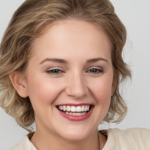 Joyful white young-adult female with medium  brown hair and blue eyes