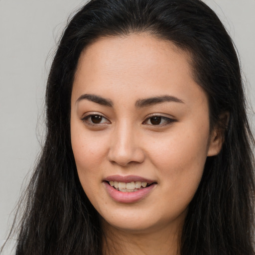 Joyful asian young-adult female with long  brown hair and brown eyes