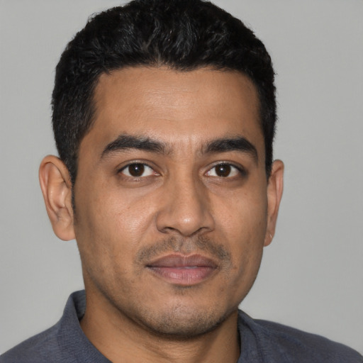Joyful latino young-adult male with short  black hair and brown eyes