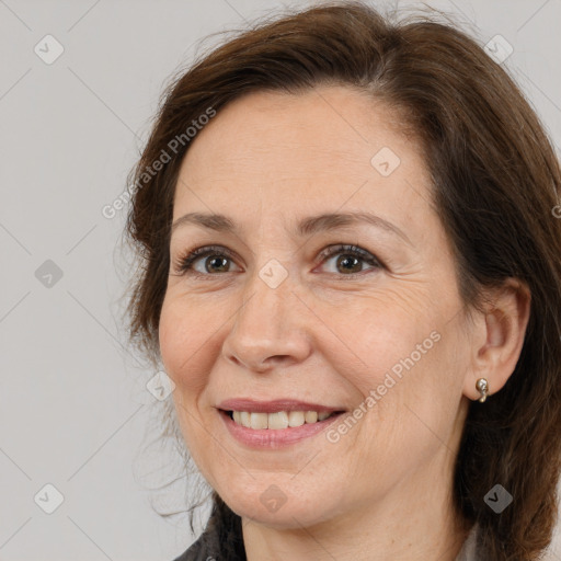 Joyful white adult female with long  brown hair and brown eyes