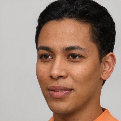 Joyful latino young-adult male with short  black hair and brown eyes