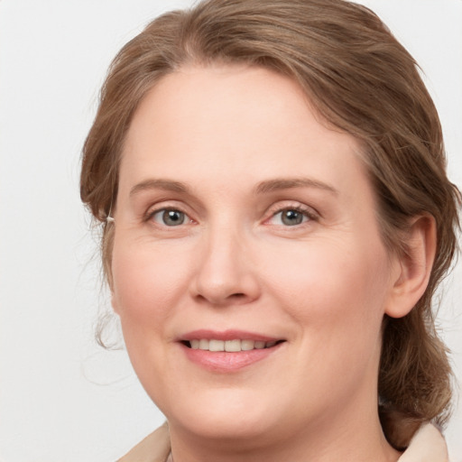 Joyful white young-adult female with medium  brown hair and blue eyes