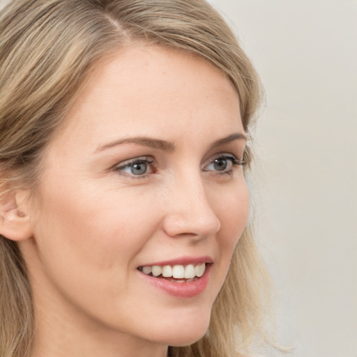 Joyful white young-adult female with long  brown hair and blue eyes