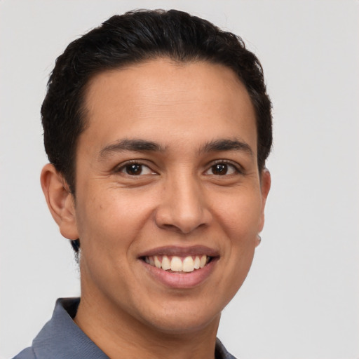 Joyful latino young-adult male with short  brown hair and brown eyes