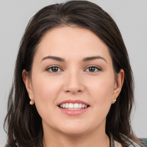 Joyful white young-adult female with long  brown hair and brown eyes