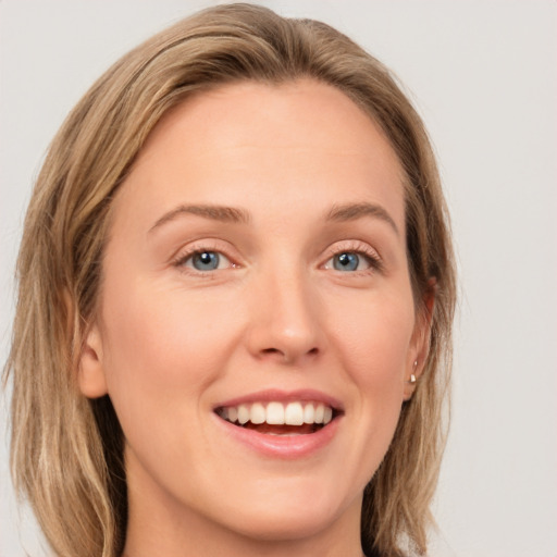 Joyful white young-adult female with long  brown hair and green eyes