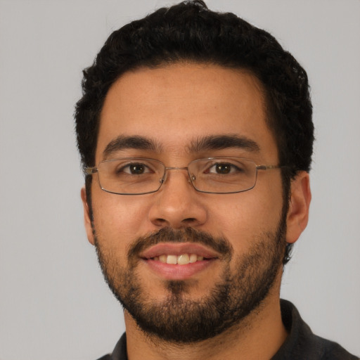 Joyful latino young-adult male with short  black hair and brown eyes