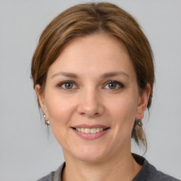 Joyful white young-adult female with medium  brown hair and grey eyes