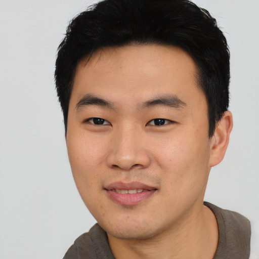 Joyful asian young-adult male with short  black hair and brown eyes