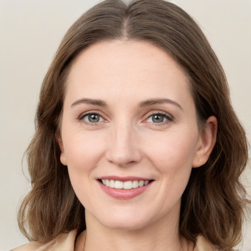 Joyful white young-adult female with medium  brown hair and grey eyes