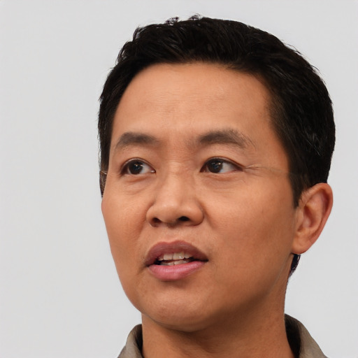 Joyful asian adult male with short  black hair and brown eyes