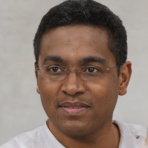 Joyful black adult male with short  black hair and brown eyes