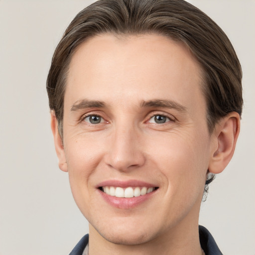 Joyful white young-adult male with short  brown hair and grey eyes