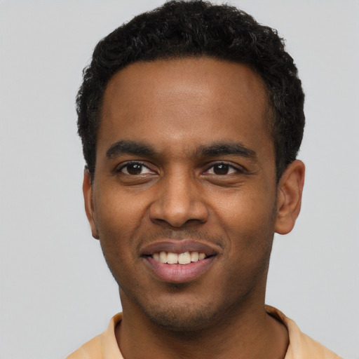 Joyful black young-adult male with short  black hair and brown eyes