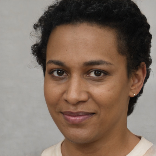Joyful black young-adult female with short  brown hair and brown eyes