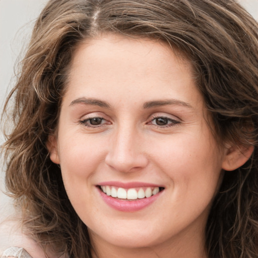 Joyful white young-adult female with long  brown hair and green eyes