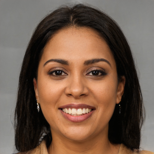 Joyful latino young-adult female with medium  brown hair and brown eyes