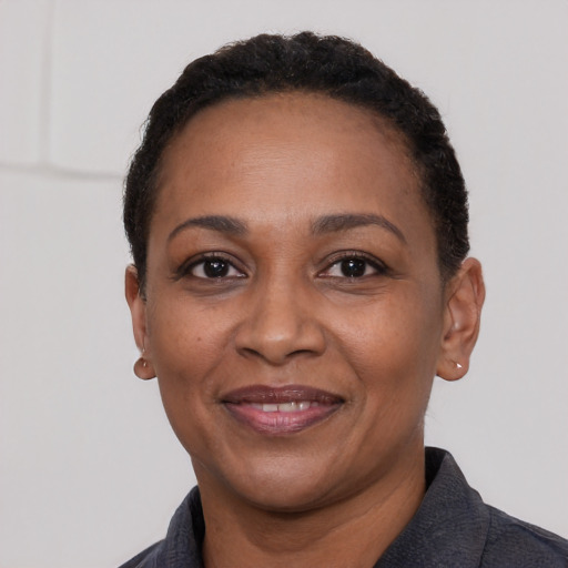 Joyful black adult female with short  black hair and brown eyes