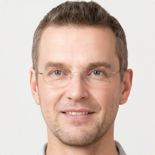 Joyful white adult male with short  brown hair and grey eyes