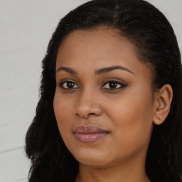 Joyful black young-adult female with long  brown hair and brown eyes