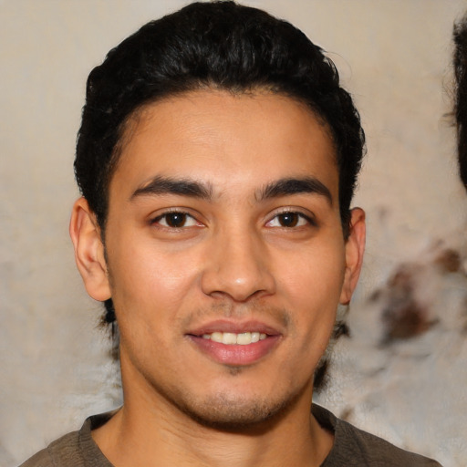 Joyful latino young-adult male with short  black hair and brown eyes